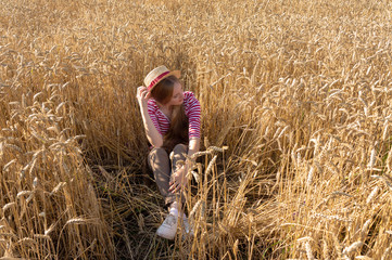 Portrait of a girl sitting in wheat.