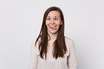 ?razy funny young woman with beveled eyes in light clothes showing tongue, fooling around isolated...