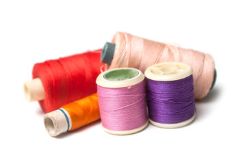 closeup of sewing thread spool bobbins on white background