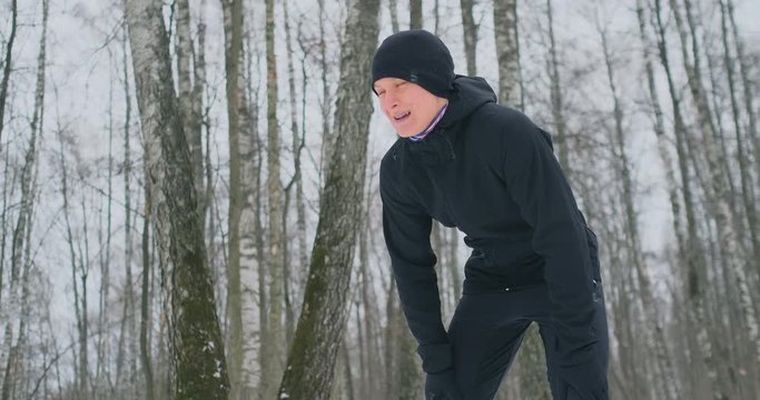 A young man on a morning jog in the winter forest was tired and stopped to catch his breath. He recovered his strength and overcame fatigue and continued to run. Perseverance and overcoming weakness