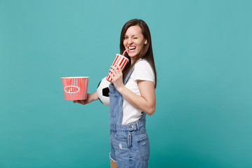 Cheerful girl football fan watching match, support favorite team with soccer ball, bucket of...