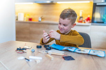 Serious little kid making diy robot, stem education concept
