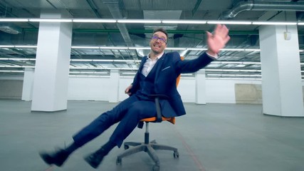 Cheerful office worker spinning on a chair, fun activity.