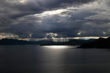 Heavenly light through thunderstorm clouds overlooking the sea and mountains off the coast of Crimea