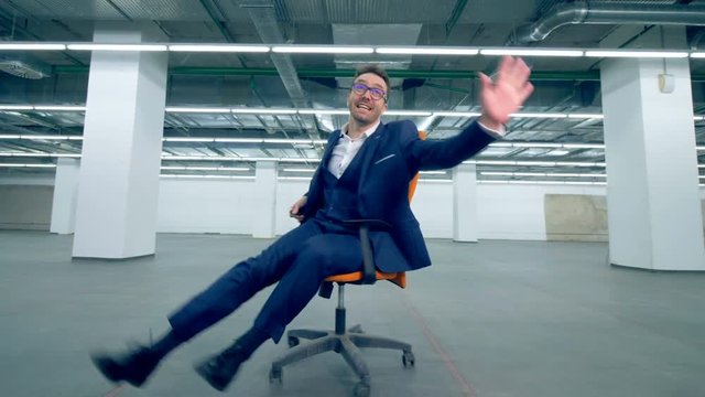 Cheerful office worker spinning on a chair, fun activity.