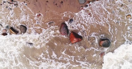 Sea waves hitting seashore in aerial view. Wild nature, stormy weather.