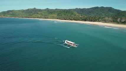 Aerial shot of a filipino touristic boat floating in turquoise pristine water. Palawan Island, Philippines