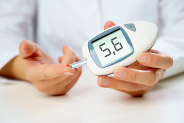 Photo of girl's hand with glucometer.