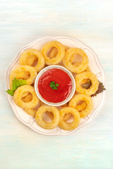 Calamari rings, shot from above with a tomato sauce dip and copy space