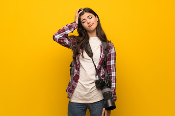 Fototapeta na wymiar Photographer teenager girl over yellow wall with an expression of frustration and not understanding