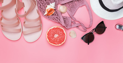 Creative flat lay composition with pink sandals, sunglasses ans other.