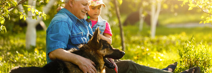 Grandfather with granddaughter dog and a dog in the garden
