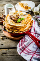 Homemade crepes with chocolate sauce, russian and ukrainian thin pancakes bliny, rustic wooden background copy space