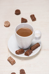 Glass of chocolate milk and variety chocolates  on table