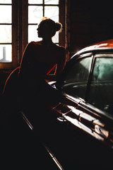 Sexy woman silhouette near retro car. Young sensual model posing for retro car show