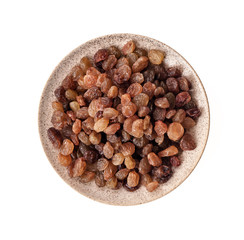 Raisins in saucer isolated on white background. Top view