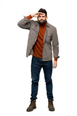 Fototapeta premium Full-length shot of Handsome man with beard looking far away with hand to look something on isolated white background