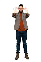 Full-length shot of Handsome man with beard counting ten with fingers on isolated white background