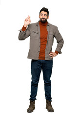 Full-length shot of Handsome man with beard with fingers crossing and wishing the best on isolated white background