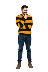 Naklejka premium Full-length shot of Handsome man with striped sweater looking to the side with the hand on the chin on isolated white background