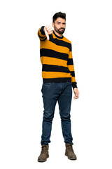 Full-length shot of Handsome man with striped sweater showing thumb down sign with negative expression on isolated white background