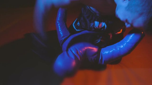 strong man warming up and boxing on mats before the ufc or Tae Kwon Do combat, male Boxer with gloves throws punches by his hands fists on mannequin sandbag, martial and muscular teen doing endurance