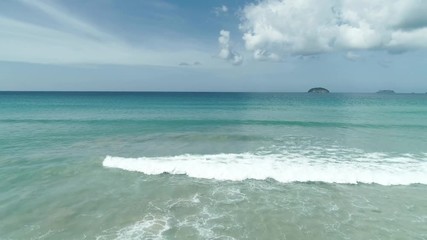 Aerial drone view of waves break on tropical white sand beach. Aerial drone view 4k shot of sea waves on the beautiful beach.