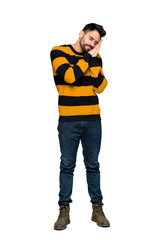 Full-length shot of Handsome man with striped sweater making sleep gesture in dorable expression on isolated white background