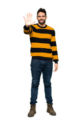 Full-length shot of Handsome man with striped sweater counting five with fingers on isolated white background