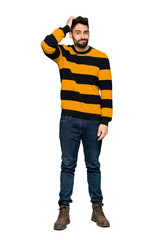 Full-length shot of Handsome man with striped sweater with an expression of frustration and not understanding on isolated white background