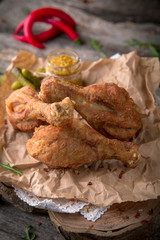 Juicy, crispy fried chicken leg for take away or food delivery  on wooden background, rustic style. Fast food 