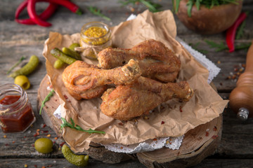 Juicy, crispy fried chicken leg for take away or food delivery  on wooden background, rustic style. Fast food 
