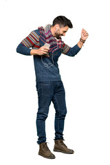 Naklejka premium Full-length shot of Hippie man listening music with the phone on isolated white background