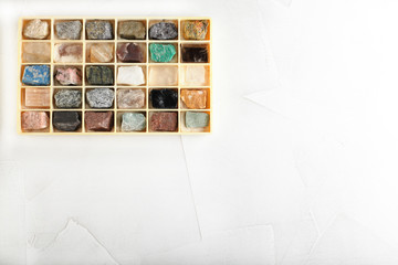 Set of minerals, a collection of rocks, minerals in the box on white cement background.