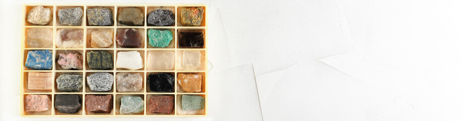 Set of minerals, a collection of rocks, minerals in the box on white cement background.