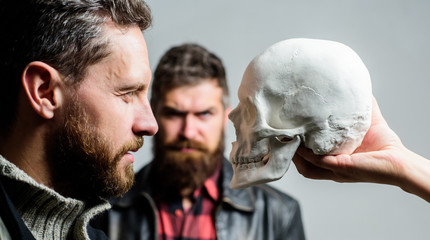 Be brave. Focused on breaking fear. Psychology concept. Human fears and courage. Looking deep into eyes of your fear. Man brutal bearded hipster looking at skull symbol of death. Overcome your fears