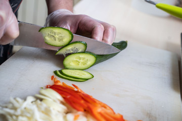 Chef cuts the vegetables into a meal. Preparing dishes. A man uses a knife and cooks.