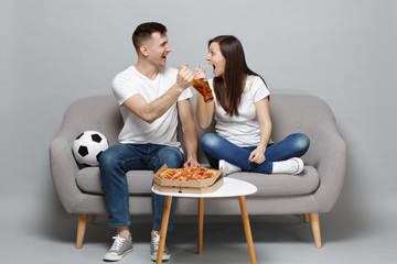 Cheerful couple woman man football fans cheer up support favorite team, looking at each other...