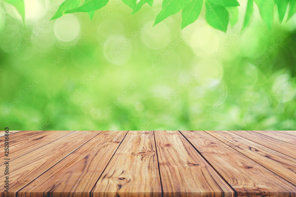 Aufkleber empty wooden deck table top on green blurred abstract background from foliage background. ready used
