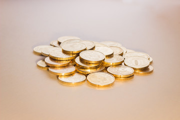 a handful of coins, similar to gold, lies on a white background