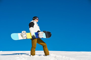 The guy is coming and preparing for skiing with snowboard