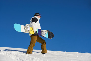 The guy is coming and preparing for skiing with snowboard