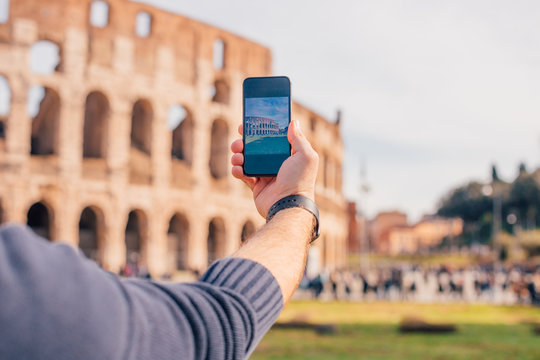 Male hand with smartphone taking picture of colosseum (Rome, Italy)