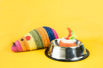 Cat toys with stainless bowl on color background.  Pet accessories concept