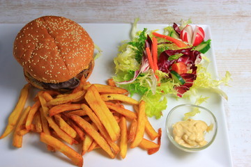 plate of hamburger with french fries,  lettuce salad and mayonnaise