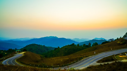 beautiful sunset sky with layer mountain and road
