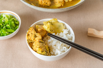 A bowl of white rice b slices of chicken and cabbage - Japanese cuisine.
