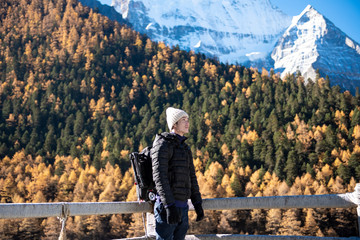 Fototapeta na wymiar A hiking man is enjoying in snow peak mountain at autumn, People traveling concept