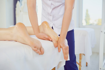 Obraz na płótnie Canvas Therapist massaging feet of client lying