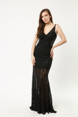 Fototapeta premium Full length photo of fashion model woman wearing elegant evening dress gown posing isolated on white wall background studio portrait. Brunette long hair girl. Mock up copy space. Black dress face view